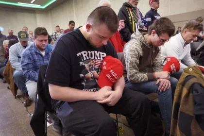 Rows of supporters for Donald Trump bow their heads in prayer.